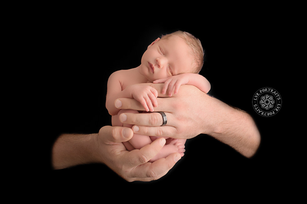 Newborn photography session, lancaster PA, newborn boy, dad's hands, black background
